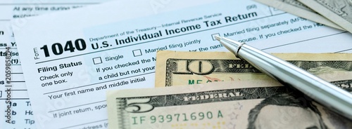 Fotografija 1040 Individual Income tax return form and pen with dollars money bills on accou