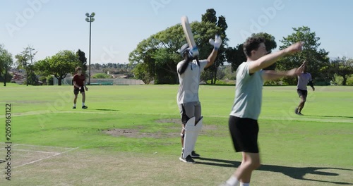 Bowler entering crease bowling on pitch batsman hitting as umpire signaling him taking guard