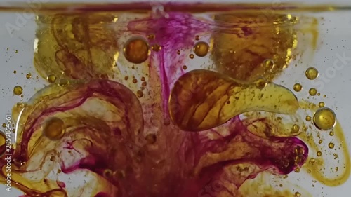 Vibrant colors mix and swirl in a mesmerizing liquid pattern on a white surface