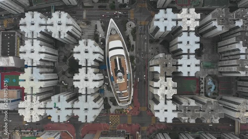 Static overhead drone shot of cruise ship shopping mall surrounded by residential apartment flats in Hong Kong