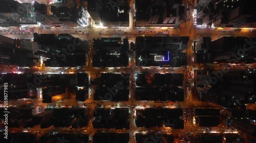 Asia infrastructure and transportation - overhead panning drone shot of illuminated streets, residential flats, and commercial office towers in Kowloon district of Hong Kong