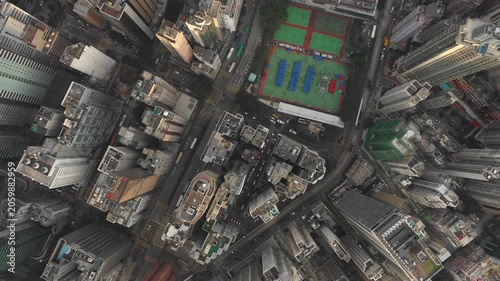 Overhead drone shot of dense high-rise apartment buildings, commercial office towers, basketball and soccer (football) fields in Hong Kong