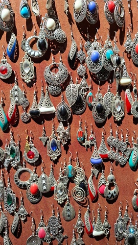 Présentoir de bijoux, pendants d'oreilles marocains traditionnels en argent et pierres précieuses exposé dans un souk