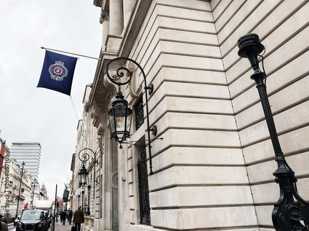 Naklejka premium Historic London street with ornate lanterns and grand stone Royal Automobile Club building facade in London, UK