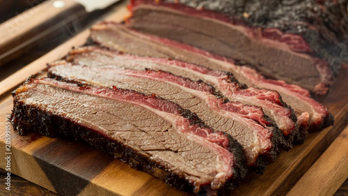 Smoked brisket slices on wooden cutting board, juicy barbecue meat with smoke ring, rustic food photography for menu