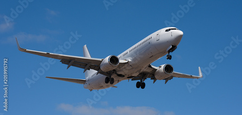 The plane lands. Airplane, passengers flying in the blue sky, preparing to land at the airport
