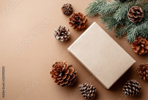 Festive holiday gift box surrounded by natural pine cones and evergreen branches