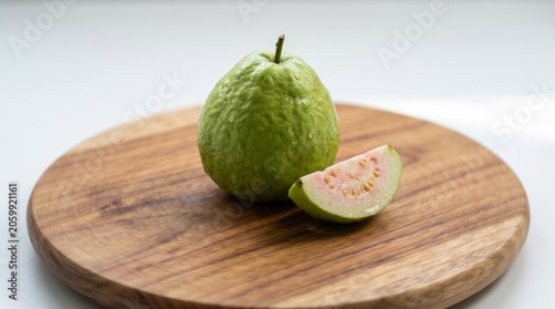 Guava fruit with slice on wooden board with bright natural lighting for healthy food advertising