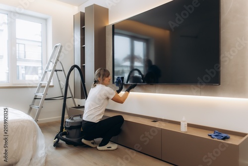 Canvas Print Woman cleaning living room television screen
