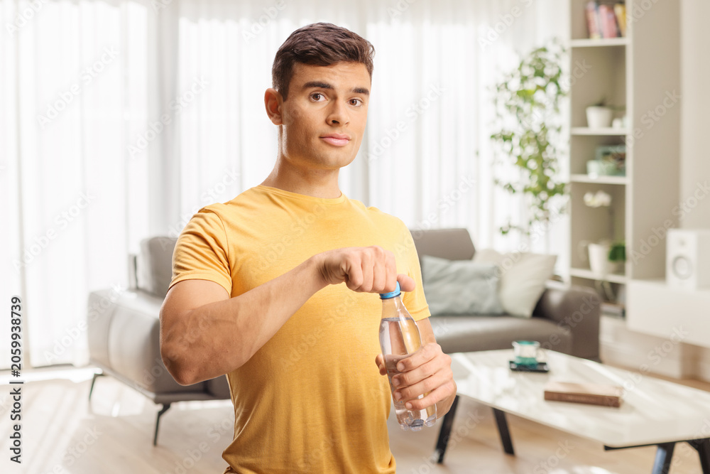 Fototapeta premium Young man opening a bottle of water