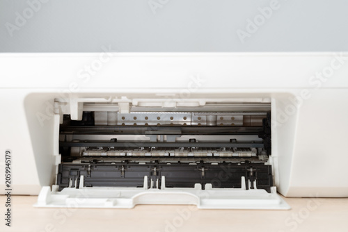 Close-up view of an open printer tray revealing internal rollers, guides and plastic parts, office maintenance, repair tutorials, technical documentation and printing workflow or troubleshooting.