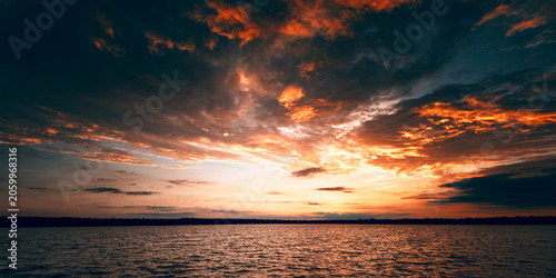 Fotografie Fiery Dramatic Sunset Over Wide River