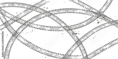 Fotografie Black tire tracks forming circular patterns on a flat surface