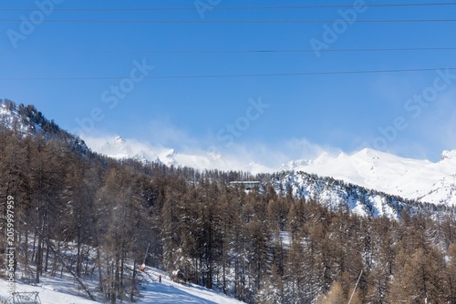 Snowy mountain landscape with skiers