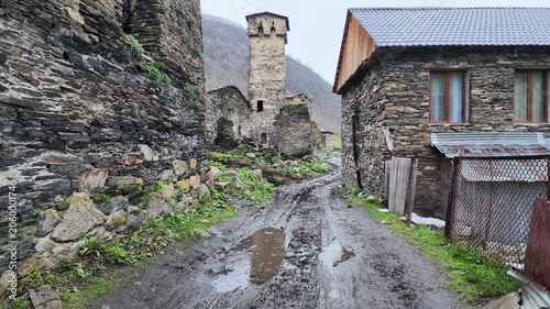 Ancient stone defensive towers in rural mountain village with muddy path, rustic architecture, historical georgian highland heritage, travel destination, Ushguli, Svaneti, Georgia