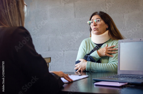 Obraz na plátně Injured senior woman explaining accident details to personal injury attorney