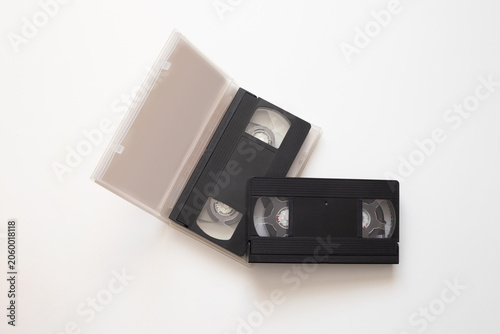 Photos Precious memories stored on old video tape with magnetic reels, video tape memories of birthdays and holidays now frozen in time, memories preserved in black plastic case on white background