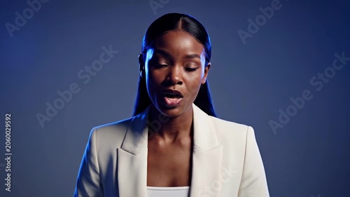 African american woman in blazer speaking to camera. Professional orator giving presentation. Business communication concept in studio setting for corporate media task.