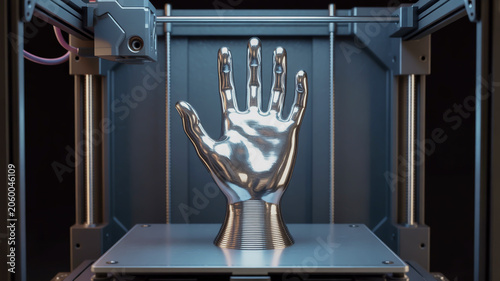 A highly detailed 3D printed metallic chrome hand sculpture inside a 3D printer enclosure.