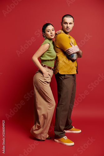 Fotografia A beautiful couple dressed in trendy outfits poses together in a vibrant studio