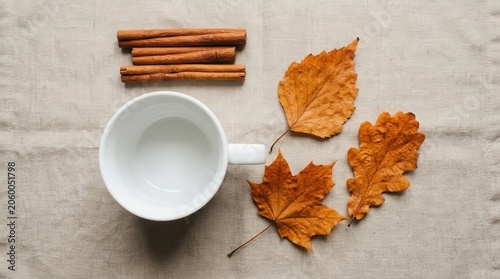 Autumnal Still Life with Cinnamon Sticks, Dry Leaves, and an Empty White Cup