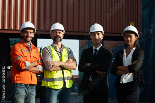 Photography Confident professionals inspect shipping containers within bustling industrial warehouse environment, wearing helmets and diverse work attire as they oversee global export logistics operations