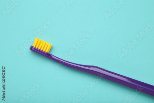 Violet toothbrush with soft bristles on blue background