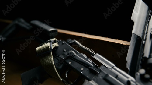 Fotografie The matte black rifle receiver sits open with its internal recoil spring assembl