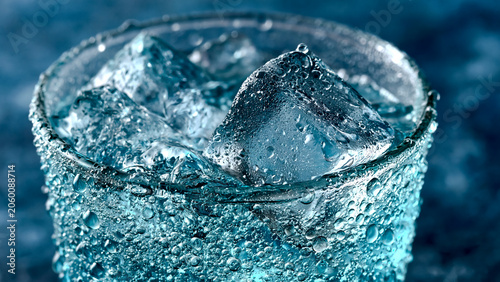 氷水がなみなみと注がれ水滴が結露した冷たいグラスのクローズアップ