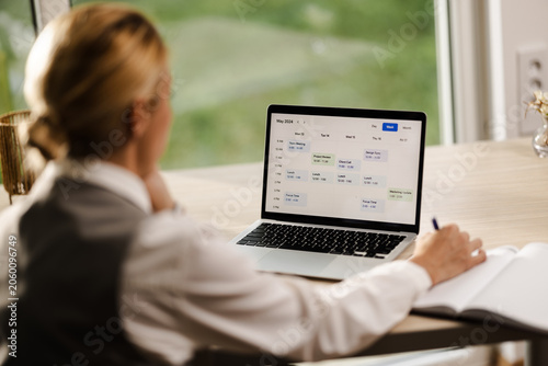 Obraz na plátně Business Professional Reviewing Weekly Schedule on Laptop at Workspace