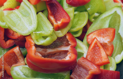close up of a mix of cut raw red and green bel peppers, raw vegetables