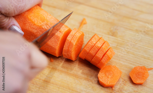 close up of cutting carrot on wooden board