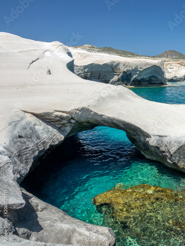 Sarakiniko beach, or moon beach with a natural arch of white volcanic rocks and transparent water in Milos, Cyclades Islands, Greece