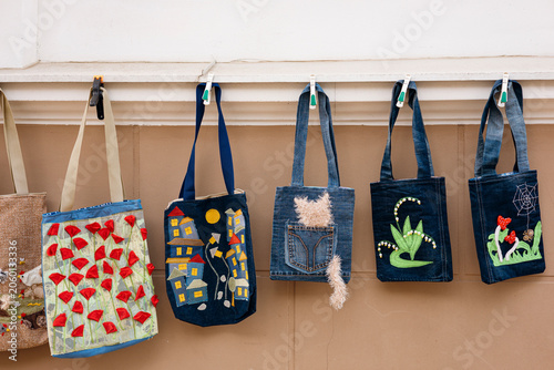 Handmade denim bags made from recycled jeans with decorative elements.