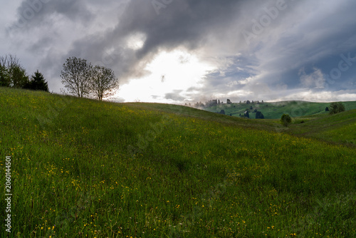 Green rolling hills under dramatic cloudy sky