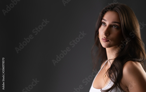 Brunette female model posing in a studio for a beauty and fashion portrait