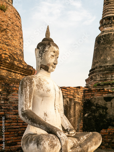 Canvas Print Weathered Buddha Statue Among Ancient Temple Ruins in Ayutthaya, Thailand