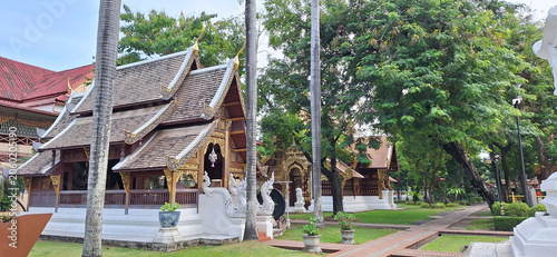 Billede på lærred Historic Lanna-style temple architecture at Wat Phra Singh under a clear blue sky, surrounded by lush green trees in Chiang Mai, Thailand