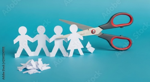 Scissors cutting a chain of paper people, symbolizing separation