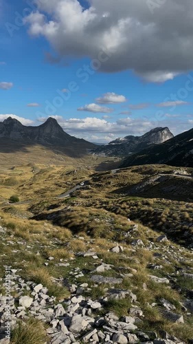 Wide mountain landscape in Gornja Bukovica, Montenegro, with rocky slopes, open valley and dramatic clouds above a scenic highland road
