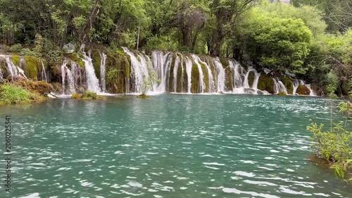 Majestic multi-tiered waterfall in Jiuzhaigou Valley UNESCO World Heritage Site, Sichuan, China – crystal clear water, in a gloomy day, in June, summer