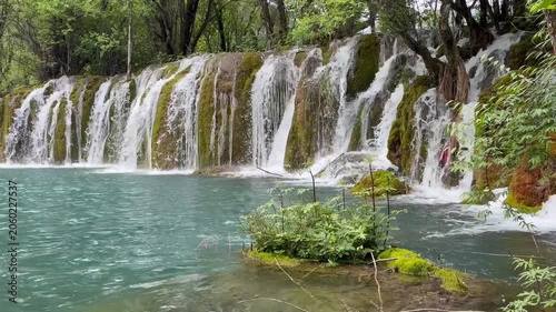 Majestic multi-tiered waterfall in Jiuzhaigou Valley UNESCO World Heritage Site, Sichuan, China – crystal clear water, in a gloomy day, in June, summer