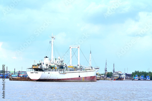 The image of ship docked at the port waiting for people and goods.