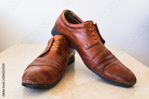 Canvas Print Worn-out old leather men's shoes that have served their time showing years of use and character