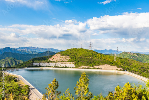 Quadro su tela Mountain Reservoir Landscape with Green Hills and Cloudy Sky