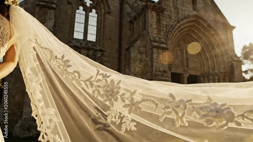 Delicate White Lace Veil Flowing in Sunlight Before Gothic Church
