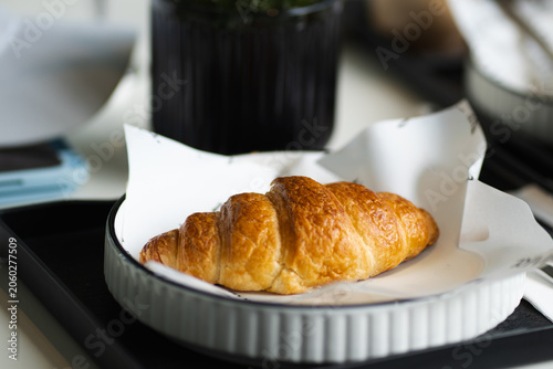 Breakfast with Croissant in white plate on table at cafe