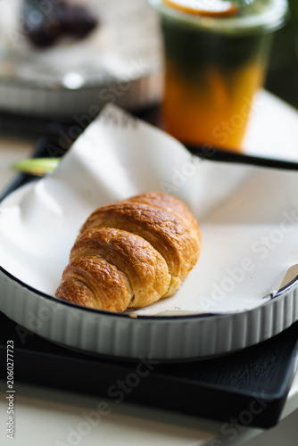 Breakfast with Croissant in white plate on table at cafe