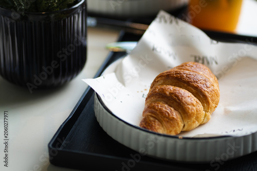 Breakfast with Croissant in white plate on table at cafe