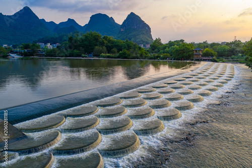 Foto Stepped River Weir with Karst Mountains at Sunset in Guilin